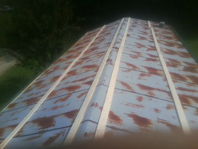 Rusted metal roof panels with new wood purlins before replacement — Storm Damage Roof Repair in Fonda by Roofing Brothers
