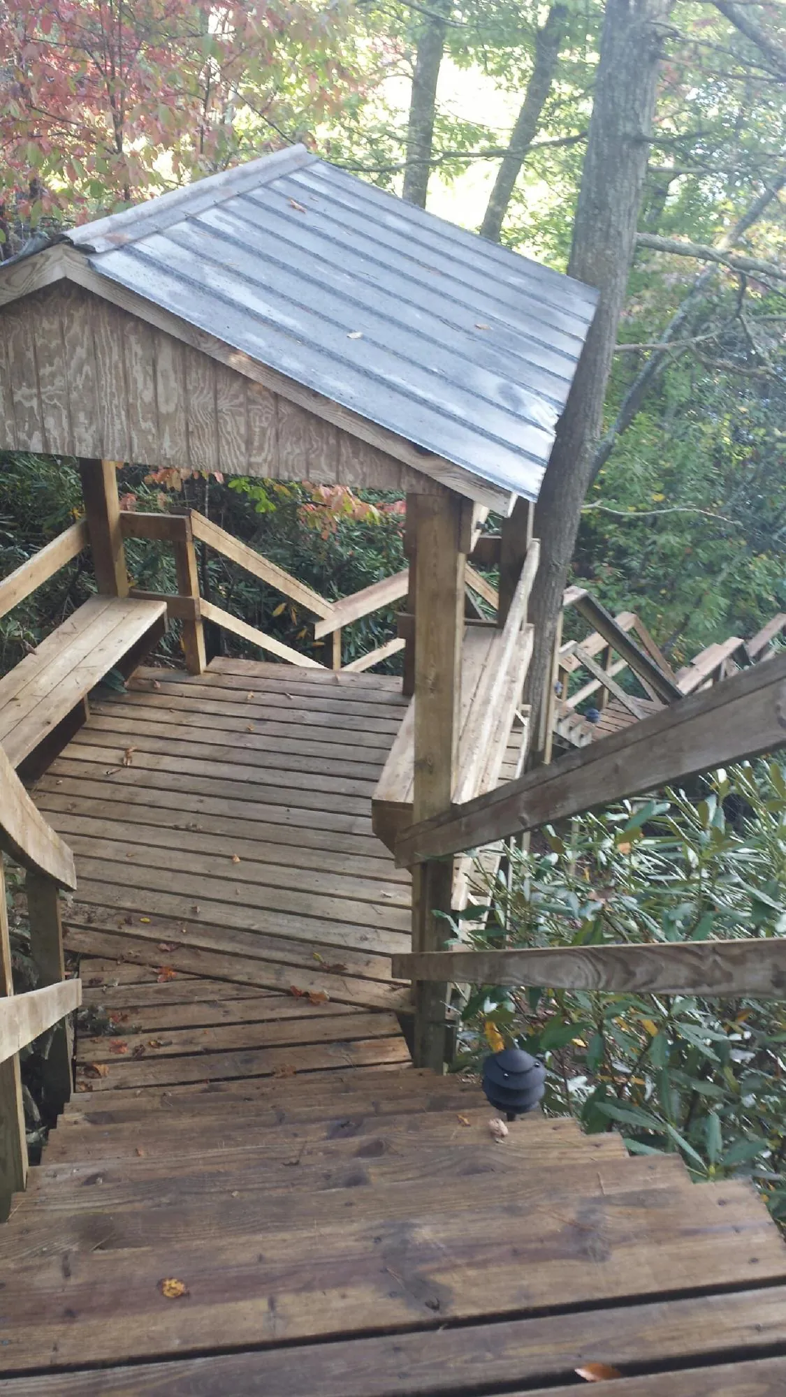 Metal roofed shelter over wooden steps on a wooded walkway — Skylight Repair & Installation work by our crew in Fonda