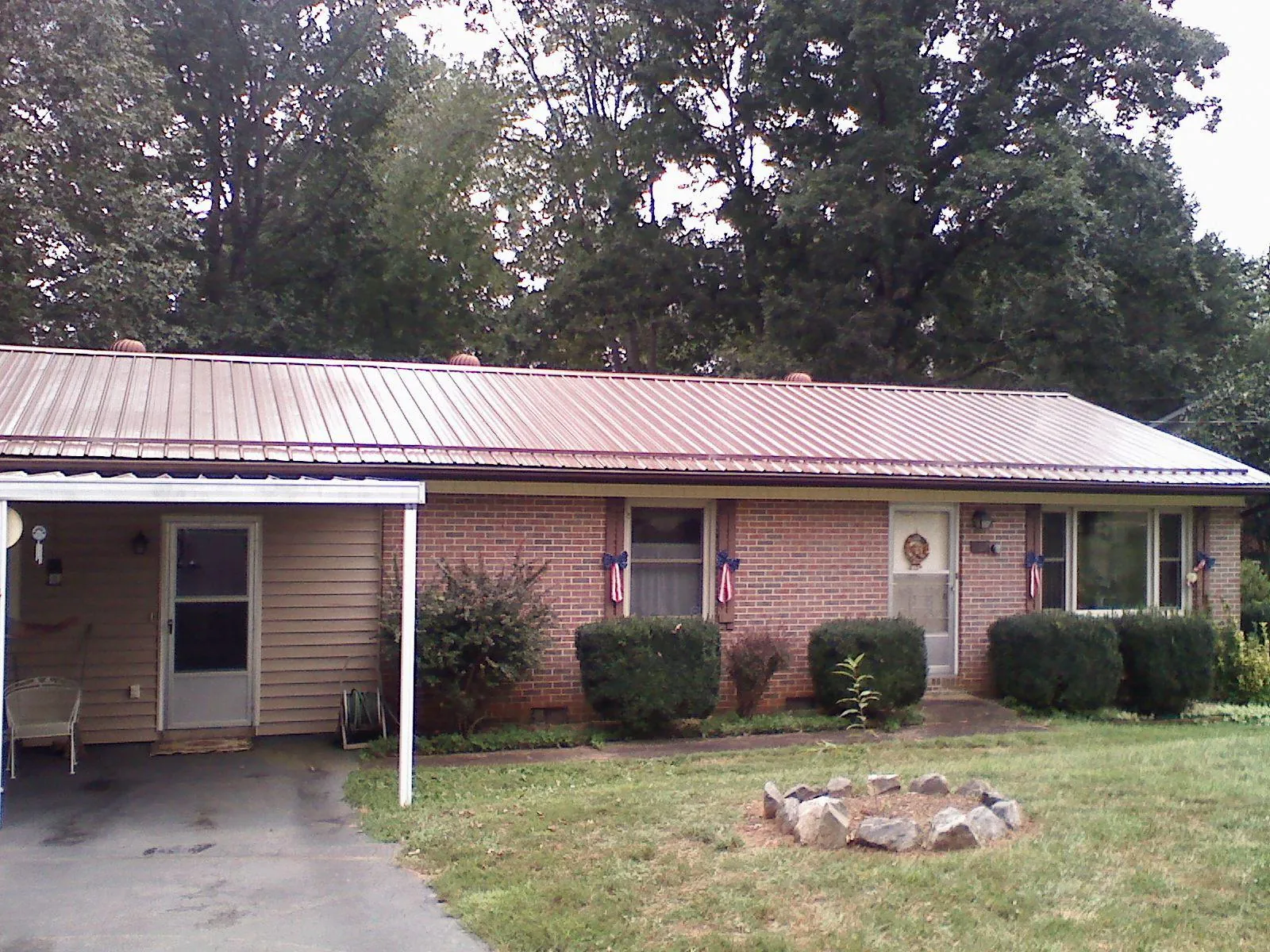 Bronze metal roof and carport on a brick ranch home — Roof Repair work by our crew in Fonda